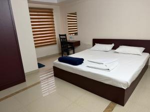 a bedroom with a large bed with two napkins on it at Staio Rooms in Thodupuzha