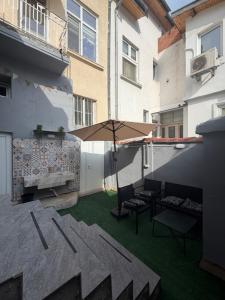 a patio with chairs and an umbrella on a building at Boho style house Varna in Varna City
