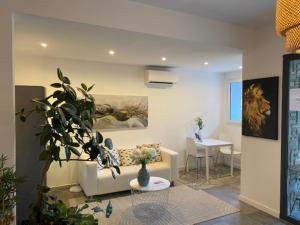 a living room with a couch and a table at L'Aiglon Bylitis in Porto-Vecchio