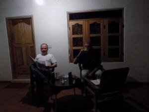 two men sitting in chairs in a room at Sajee Residence Nilaveli in Trincomalee