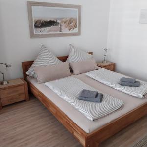 a bedroom with a bed with two pillows on it at Pension am Bernsteinmuseum - Doppelzimmer in Ribnitz-Damgarten