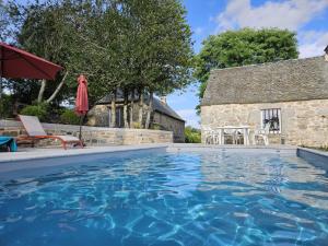 a swimming pool in front of a house with a building at La Borie de Peyrot in Huparlac