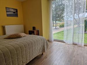 a bedroom with a bed and a large window at La Borie de Peyrot in Huparlac +33 photos