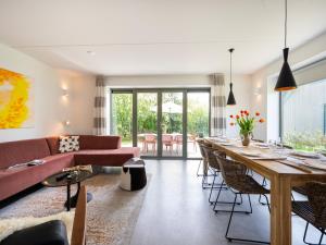 a living room with a long table and a couch at Aan Noordzee Villa Veranda huisdier toegestaan max 2 in Sint Maartensvlotbrug