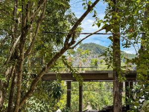 a bridge in the middle of a forest with trees at Seven Minutes Ella by SANS in Ella