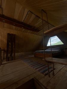 an attic room with a bunk bed and a window at Мисливський Дворик in Solochyn