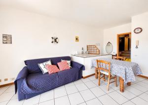 a living room with a blue couch and a table at Hostdomus - Phil House in Finale Ligure