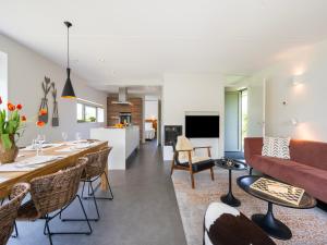 a living room with a couch and a table at Aan Noordzee Villa Veranda huisdier toegestaan max 2 in Sint Maartensvlotbrug