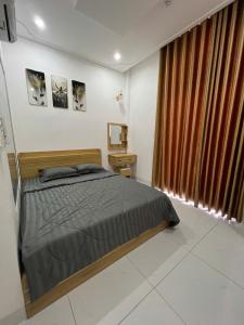 a bedroom with a bed and a large window at Lya Homestay CMT8 Da Nang in Danang +3 photos