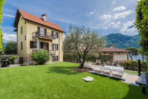 ein Haus mit einem grünen Garten mit zwei Bänken in der Unterkunft Villa Ida by Rent All Como in Como