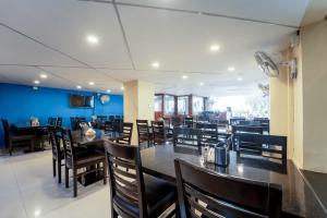 a dining room with black tables and chairs at Panaji Residency in Panaji