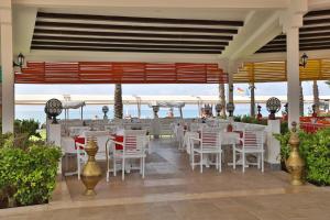 a restaurant with white chairs and the ocean in the background at Crystal Family Comfort Collection - Ultimate All Inclusive in Belek