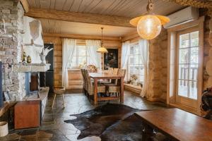 a living room with a table and a fireplace at Metskapteni Puhkemaja in Põõsaspea