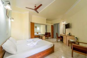 a hotel room with a bed and a desk at Farmagudi Residency in Ponda