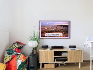 a living room with a tv on a wall at Le Blériot in Sangatte