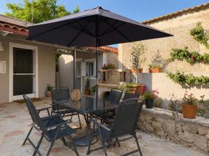 ein Tisch und Stühle mit einem Sonnenschirm auf einer Terrasse in der Unterkunft Selene House in Volímai + 17 Fotos