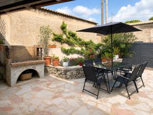 eine Terrasse mit einem Tisch, einem Sonnenschirm und einem Kamin in der Unterkunft Selene House in Volímai
