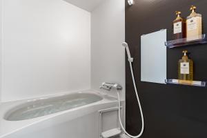 a bathroom with a bath tub with two bottles of alcohol at 楓 和室の一棟貸切 最大10名宿泊可能 駅徒歩2分 関西空港直通 in Osaka +35 photos