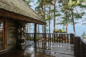 a porch of a log cabin with a thatch roof at Metskapteni Puhkemaja in Põõsaspea +20 photos
