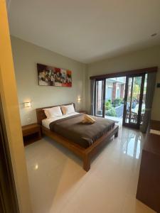 a bedroom with a bed and a large window at 21REDA Cozy Stay in Uluwatu