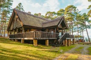 a log cabin with a porch and a deck at Metskapteni Puhkemaja in Põõsaspea
