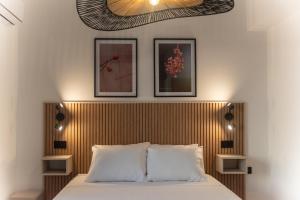 a bedroom with a bed with a wooden headboard at Gallery Home in Kardamaina