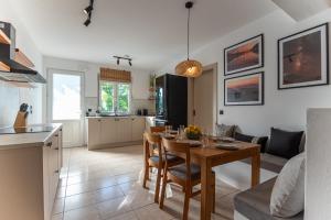 a kitchen and living room with a wooden table and a dining room at Gallery Home in Kardamaina