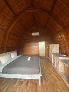 a bed in a room with a wooden ceiling at 21REDA Cozy Stay in Uluwatu +4 photos