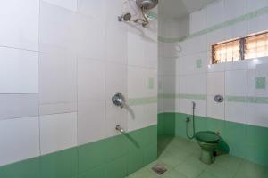 a bathroom with a toilet and a shower at Farmagudi Residency in Ponda +18 photos