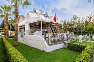 a white boat in a park with palm trees at Crystal Sunset Pearl Collection - Ultimate All Inclusive in Side