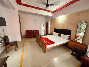 a bedroom with a bed and a chair in it at Hotel Welcome Palace in Patna