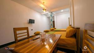 a room with two beds and a wooden table at MSResort in Haputale