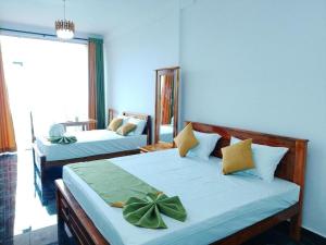 a bedroom with two beds and a large window at MSResort in Haputale