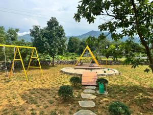 a park with a swing set and a playground at Flora Garden in Làng Hang