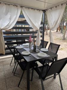 a black table with chairs and a bottle of wine at BARKA House Pakoštane in Pakoštane