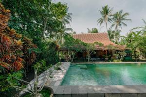 a swimming pool in front of a house at Sikepan Villa Borobudur in Mendut