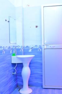 a bathroom with a white sink and a refrigerator at Prabhanjanam Residency in Ayodhya +34 photos