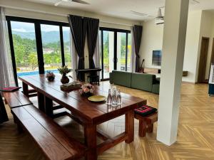 a living room with a wooden table and a couch at Flora Garden in Làng Hang