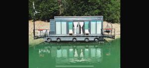 a tiny house sitting on top of a body of water at Black Swan Lakehouse in Bicaz