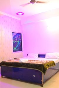a bed in a room with a pink wall at Prabhanjanam Residency in Ayodhya