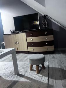 a living room with a chair and a dresser at Apartament Teo -Rewal in Rewal