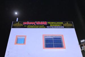 a sign on the side of a white building at Prabhanjanam Residency in Ayodhya
