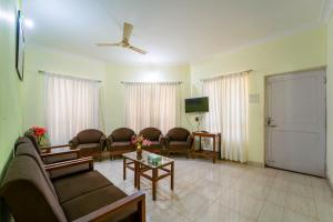 a living room with a couch and chairs and a tv at Farmagudi Residency in Ponda