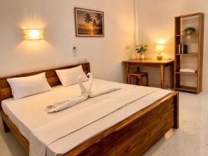 a bedroom with a large bed with a towel on it at Royal Palms Resort in Arugam Bay