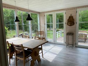 ein Esszimmer mit einem Holztisch und Stühlen in der Unterkunft Magical hide-away in the forest in Trensum