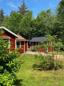 ein rotes Haus mit einem Vorgarten in der Unterkunft Magical hide-away in the forest in Trensum