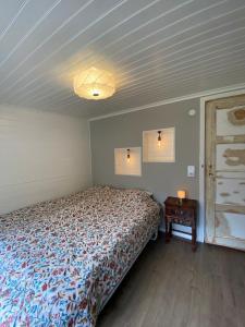 ein Schlafzimmer mit einem Bett und einem Nachttisch mit einem Tisch in der Unterkunft Magical hide-away in the forest in Trensum