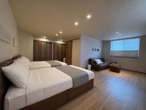 a bedroom with a large bed and a couch at Fubuki Kimobetsu in Abuta