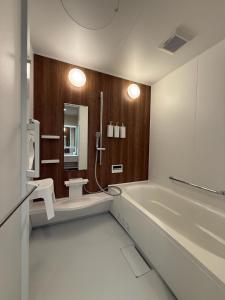 a bathroom with a tub and a toilet and a sink at Fubuki Kimobetsu in Abuta +15 photos