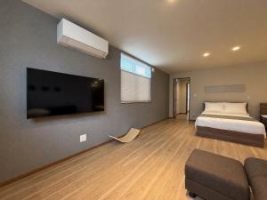 a bedroom with a bed and a flat screen tv at Fubuki Kimobetsu in Abuta